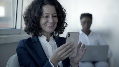 Cheerful-businesswoman-using-smartphone