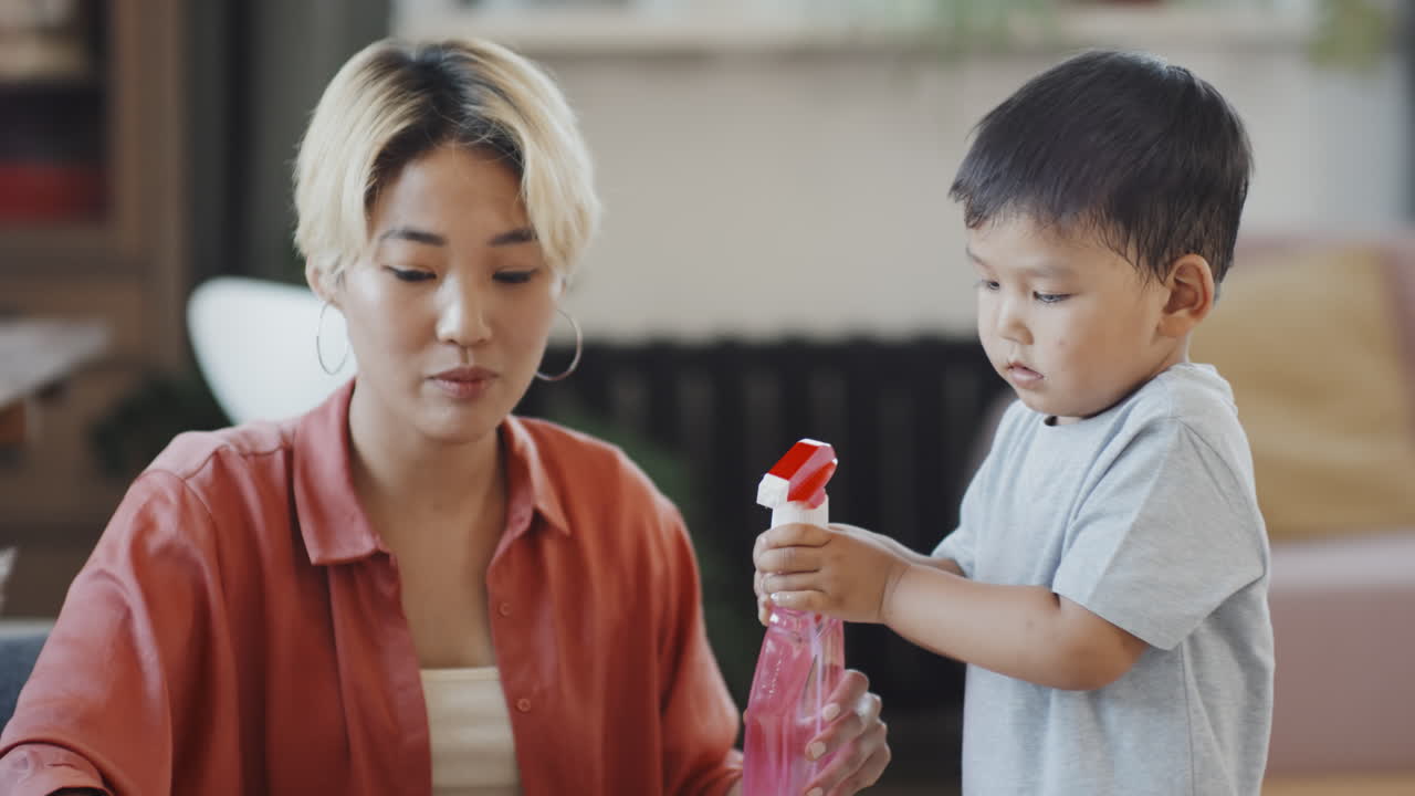 Asian Woman with Son Wiping Table at Home