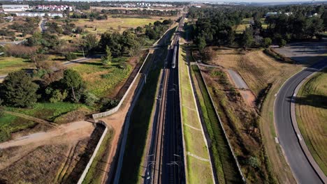 The-Gautrain,-along-its-journey-to-OR-Tambo-Airport,-passes-by-below