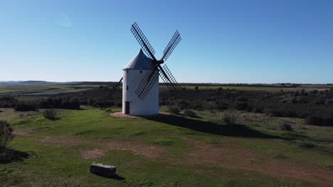 Aufsteigende-Szene-Der-Weißen-Traditionellen-Windmühle-Mittelalterlich-Umgeben-Von-Grünen-Wiesen-Quijote