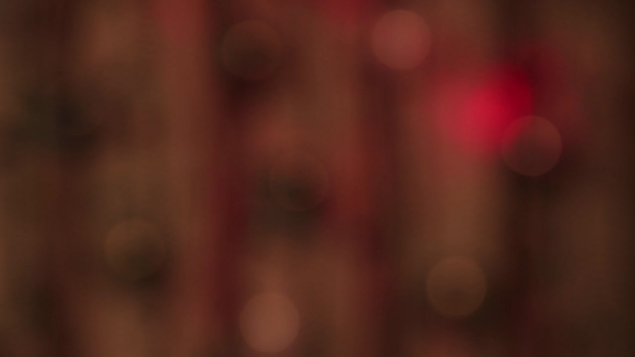 luces blancas suaves y festivas se balancean en la oscuridad y un rápido rayo rojo.