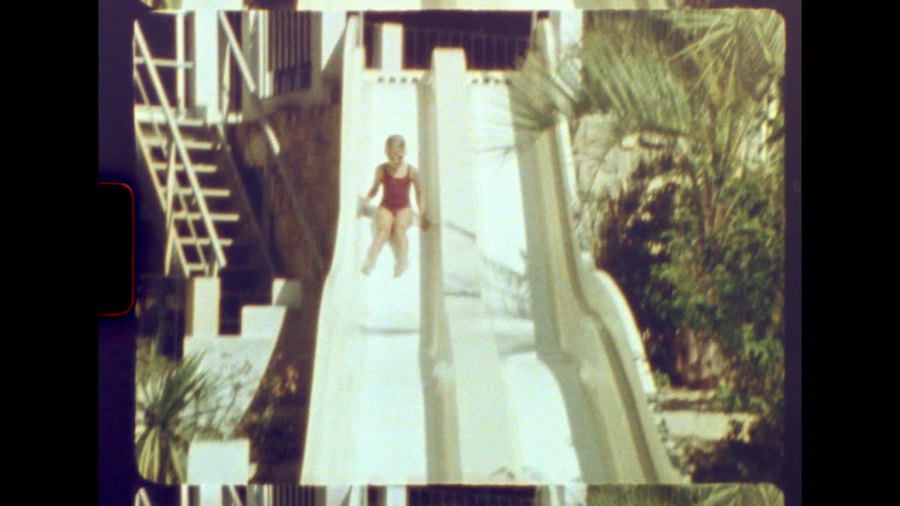 Vintage girl sliding into swimming pool on sunny day