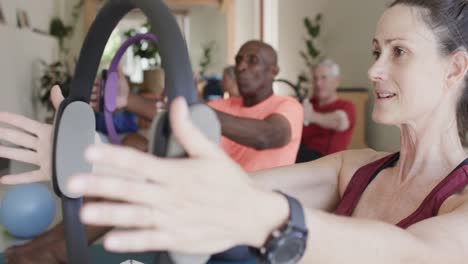 diverse senior people exercising at house with female coach and circles in slow motion