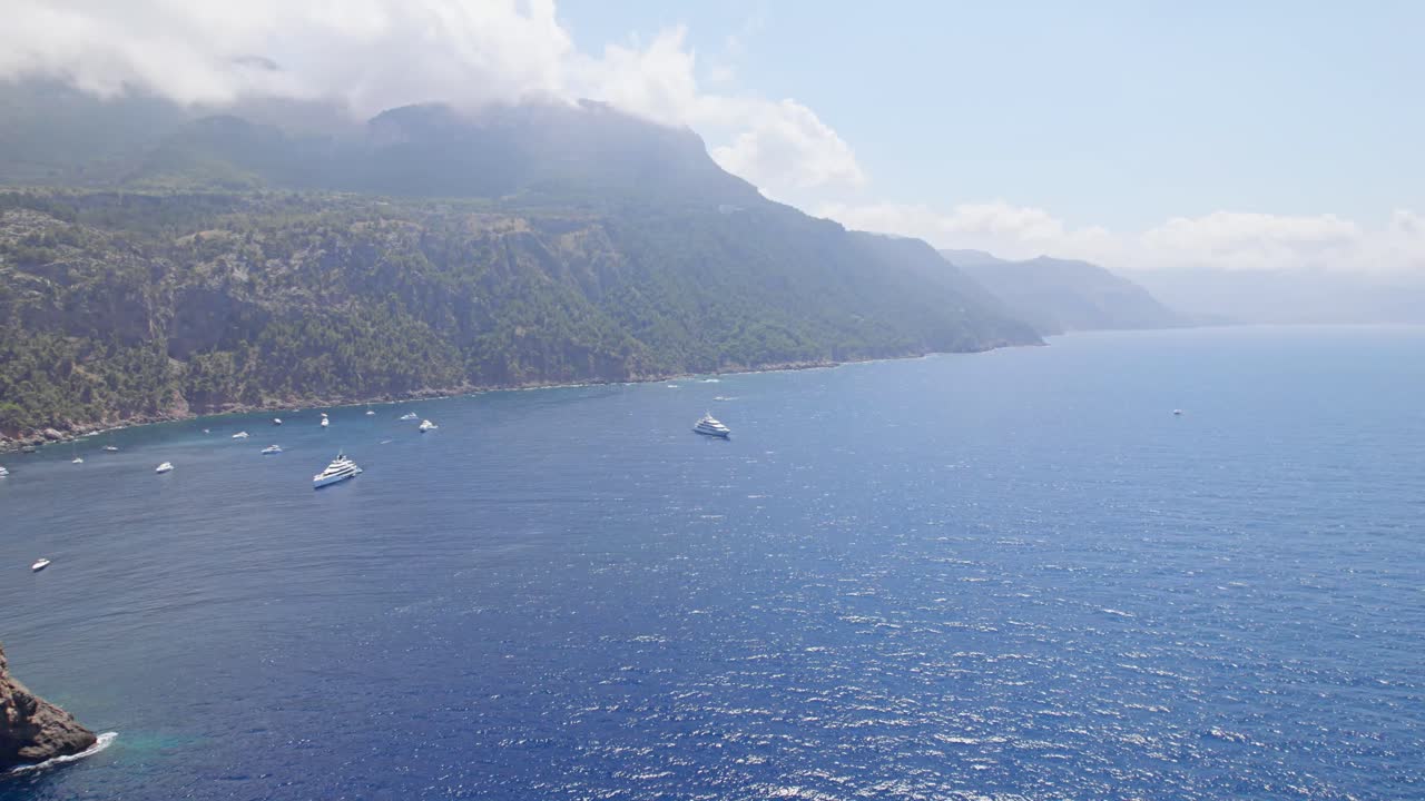태양 아래 구름과 많은 요트 정박지가 있는 산만에서 뒤로 날아가다