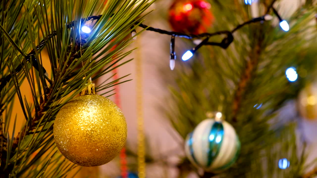 la decoración de navidad y año nuevo. las joyas colgantes de cerca. el fondo de vacaciones de bokeh borroso y abstracto. la guirlanda parpadeante. las luces del árbol de navidad parpadeando.