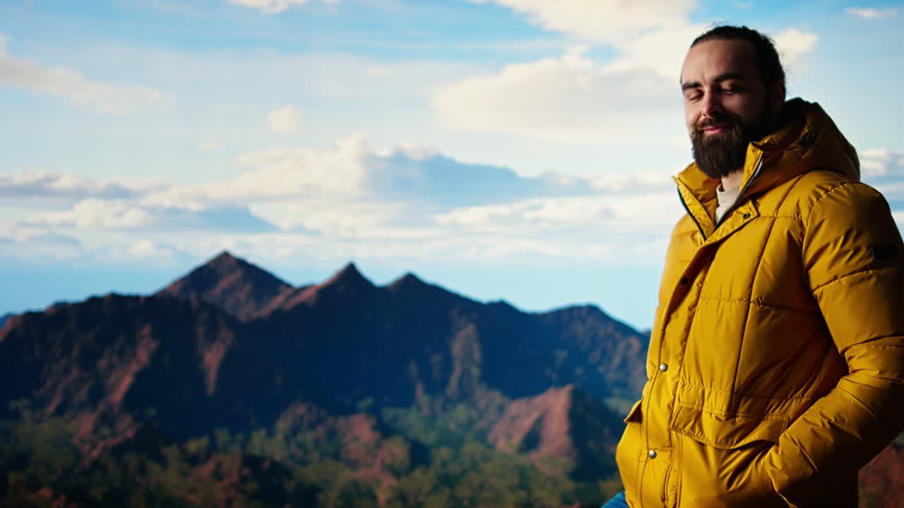 un excursionista vestido con ropa cálida se encuentra en un pico de montaña