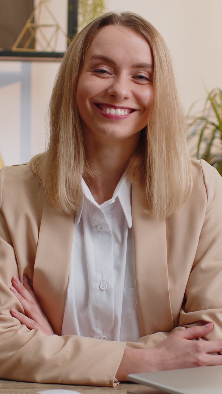 Giovane donna d'affari seduta alla scrivania dell'ufficio che chiude il laptop dopo aver terminato lo smart working