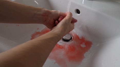 A-Murderer-or-Serial-Killer-Washing-His-Bloody-Hands-in-a-Sink,-Close-up