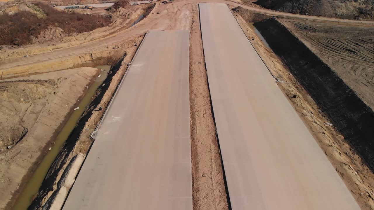 Aerial fly over the concrete freeway lanes under construction