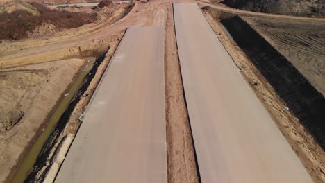 aerial fly over the concrete freeway lanes under construction