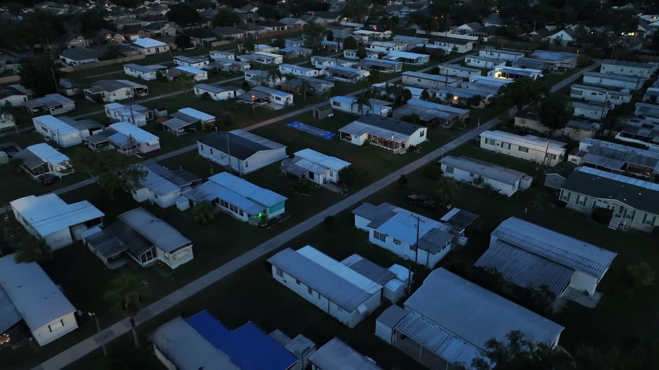 Mobile Trailer homes in quiet suburbia of American town. Night scene in cheap and social district of plant city, Florida. Aerial Birds Eye shot. Sleeping American neighborhood