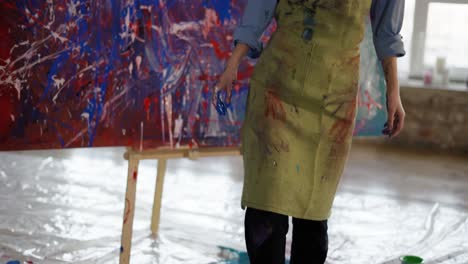 Portrait-female-painter-after-finishing-her-masterpiece-in-art-studio