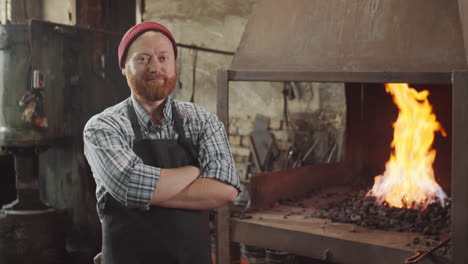 portrait of professional blacksmith near forge