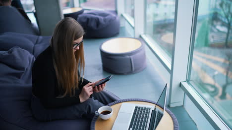 beautiful young woman working on laptop computer while drinking coffee