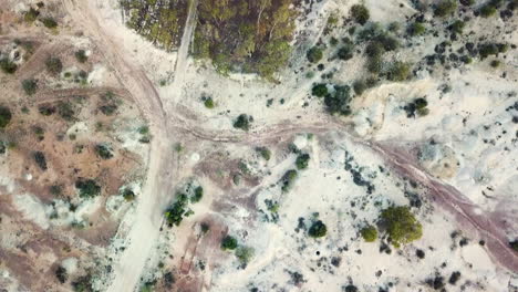 drone moviéndose hacia adelante mirando directamente hacia abajo mostrando el interior australiano con la icónica suciedad roja, naranja y blanca