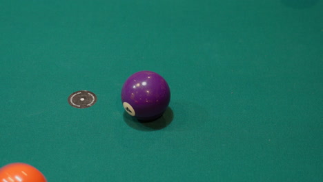 billardkugeln werden auf einem 9-ball-diamantgestell zerbrochen, nahaufnahme auf der stelle mit festen und gestreiften billardkugeln, die mit grünem filz oder tuch über den tisch verstreut sind, bruchansicht von oben