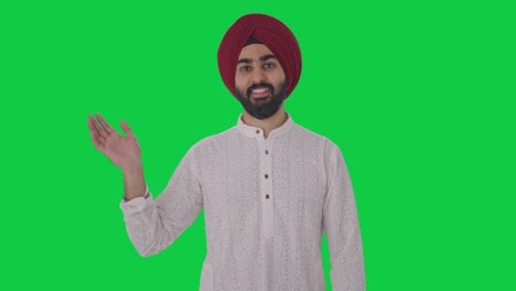 happy sikh indian man saying hello green screen