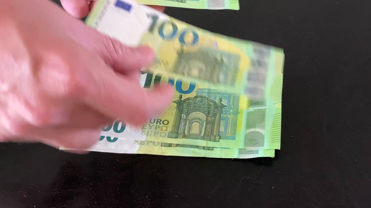 las manos del hombre cuentan billetes de 100 €
