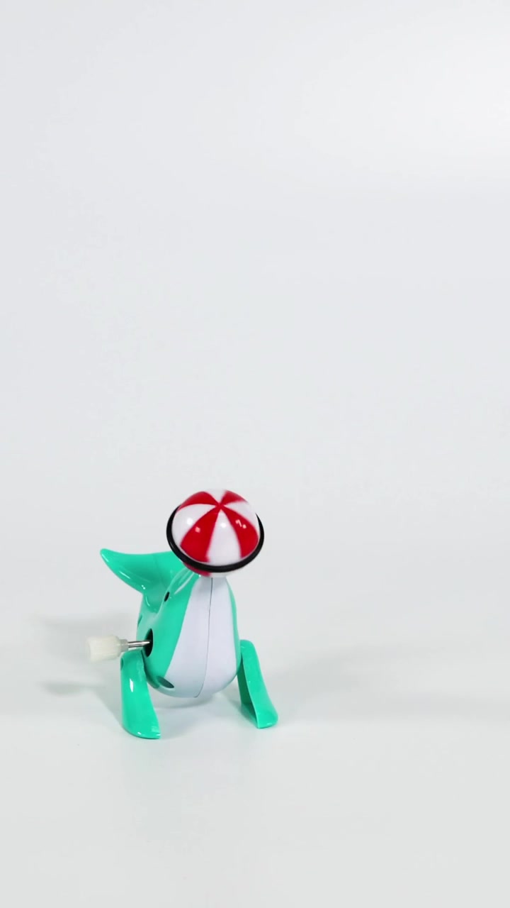 Toy dinosaur encounters and interacts with spinning top.