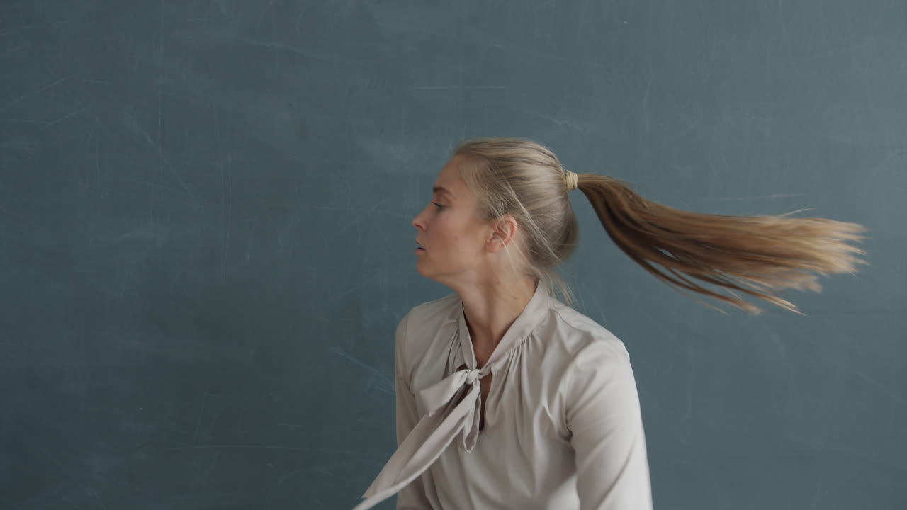 Woman Dancing in Front of a Blackboard