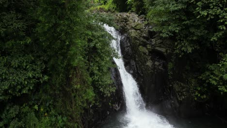 Ein-Kleiner-Wasserfall-Zwischen-Bäumen-Und-Felsen-In-Bali,-Indonesien