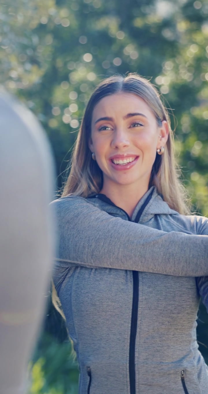 Mujer joven haciendo ejercicio y estirando al aire libre con un compañero