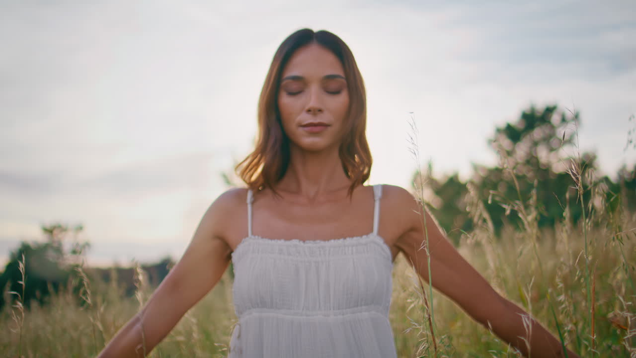 Meditative woman standing field spreading arms closeup. Closed eyes brunette