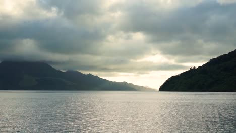 beautiful view from boat of ocean, hills and clouds in marlborough sounds, new zealand