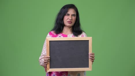mujer india hermosa madura mostrando la pizarra y asintiendo con la cabeza no