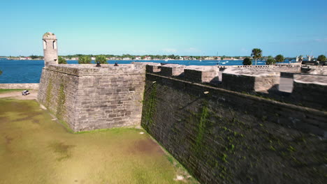 Aerial-view-close-to-the-walls,-rising-over-the-cannons-of-the-Castle-of-San-Marcos,-in-sunny-Florida,-USA