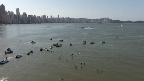 gente nadando en el mar cerca de jetskis flotando en balneario camboriu, santa catarina, brasil en verano