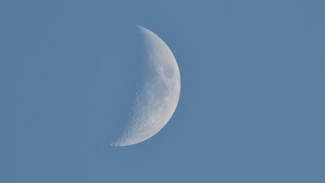 crescent moon rising in blue sky during daytime, isolated against a clear sky backdrop background with space for text