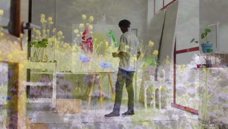 animation of african american man painting over landscape