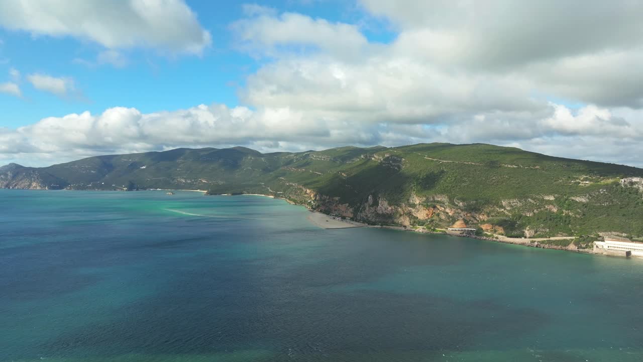 Aerial establishing shot of Arrabida natural park scenery by turquoise colored water, Setubal