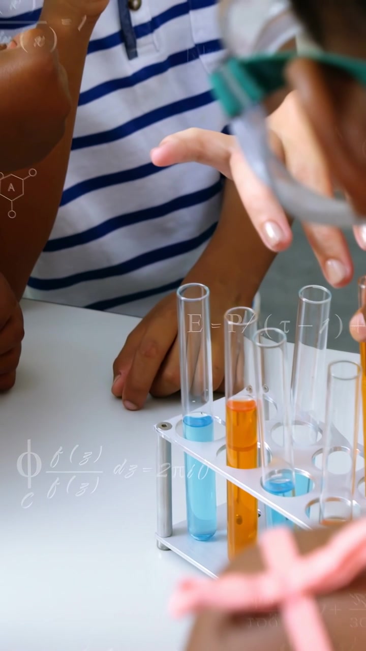Vertical video: Lead guiding kids with pipette making tube color change in lab with formula on desk