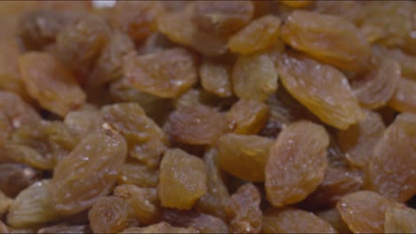 a zooom out and steady shot of golden raisins on a table