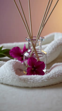 scented diffuser with purple flowers and soft white towel