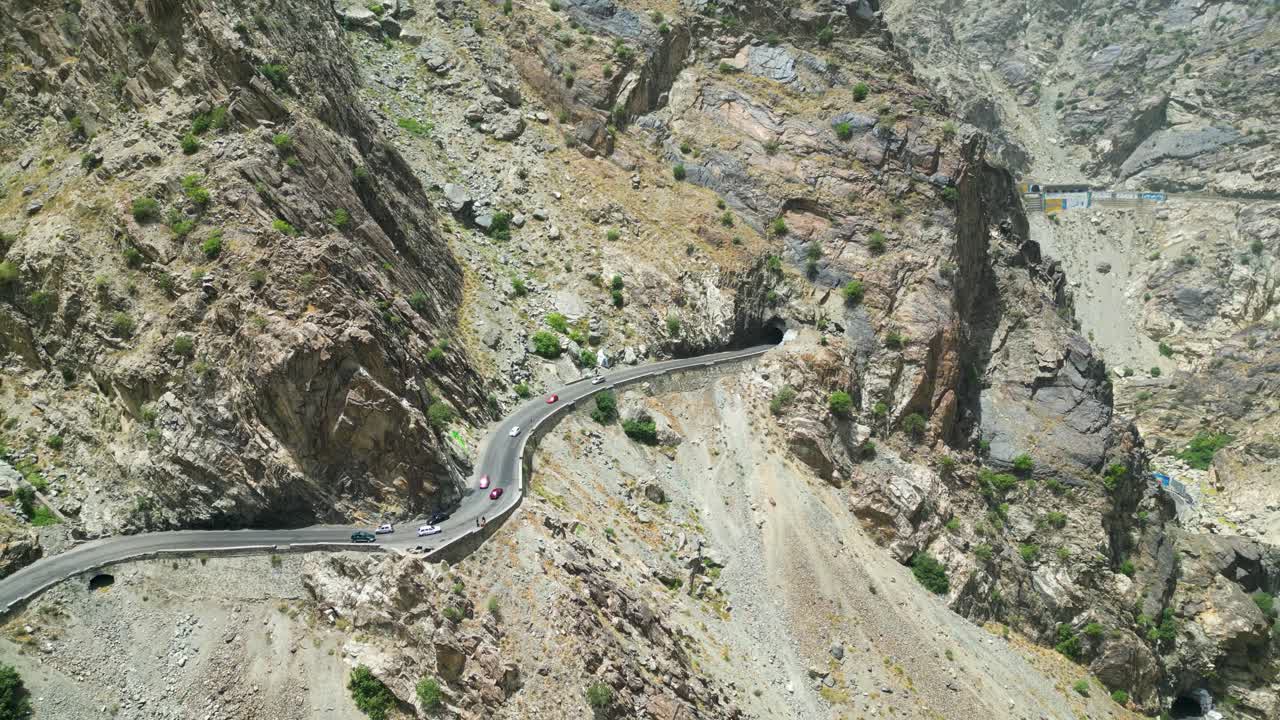 Dangerous Winding mountain roads and tunnel in arid Hindu Kush mountains near Kabul, Afghanistan bordering Pakistan. Drone Aerial