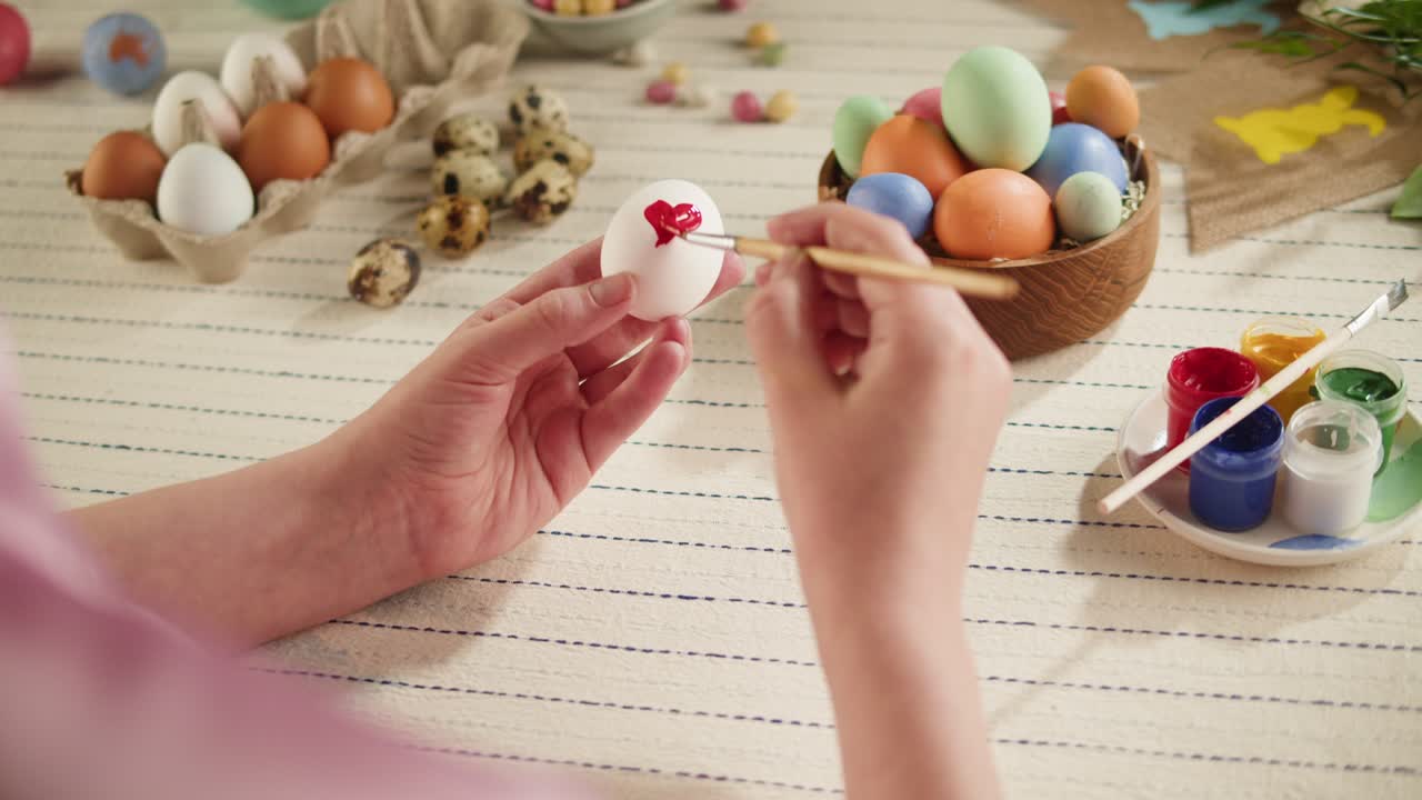 Happy Easter holiday. Coloring eggs top view. Woman preparing for Easter, painting and decorating eggs. Christian celebration, family traditions.
