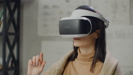 portrait woman architect designer in virtual reality helmet with hands imitates work of interface. designing the future the concept of virtual architecture and design interface graphic applications.