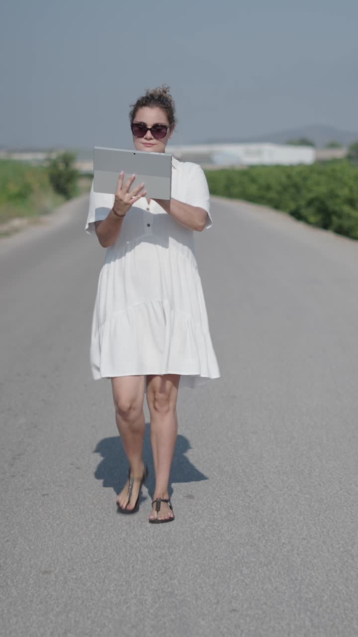 Donna con tablet che cammina sulla strada