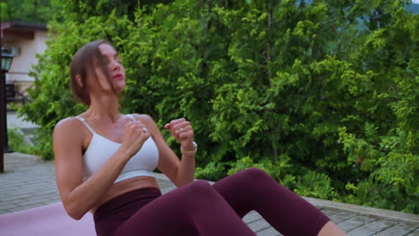 mujer haciendo ejercicios abdominales al aire libre