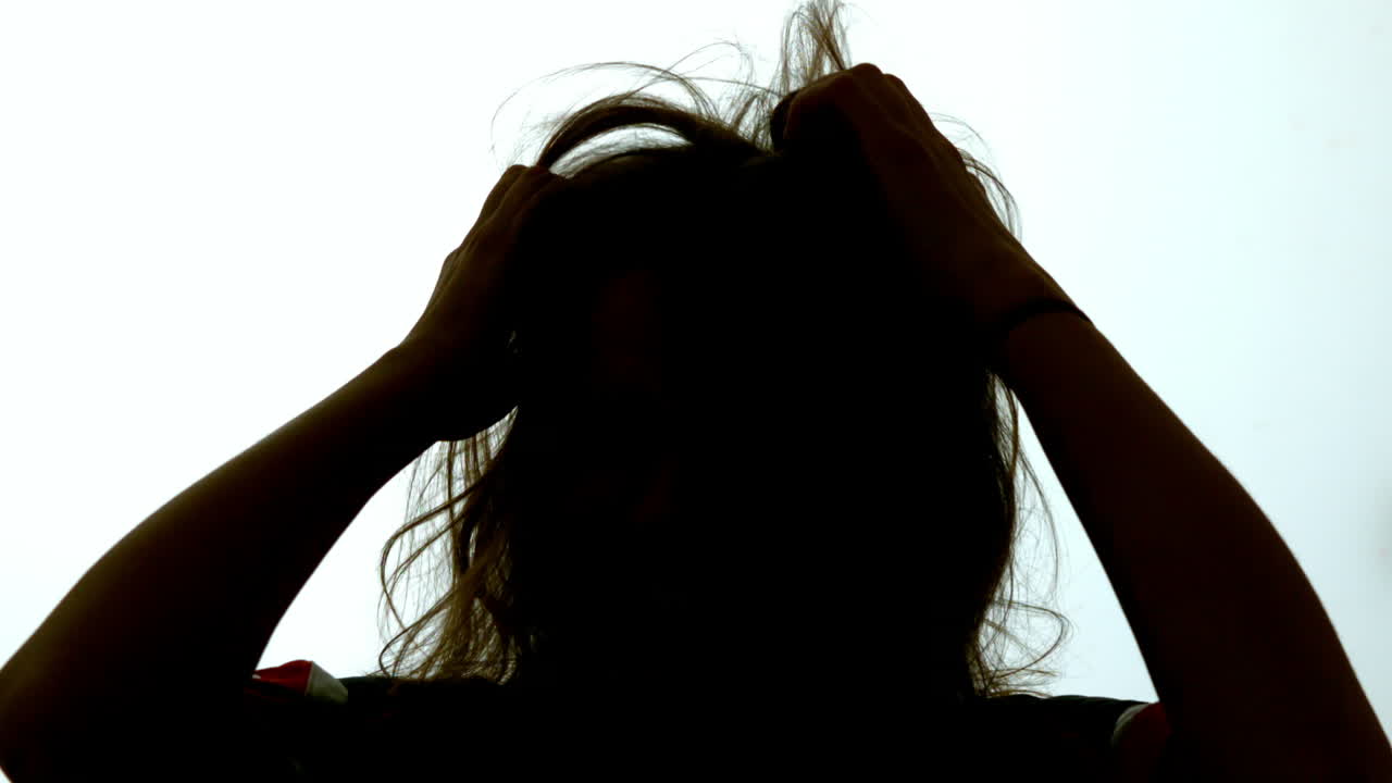 머리카락을 당기는 매력적인 여성의 실루