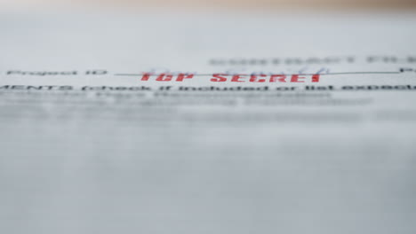 top secret sign stamping on important document close up. hand holding seal.