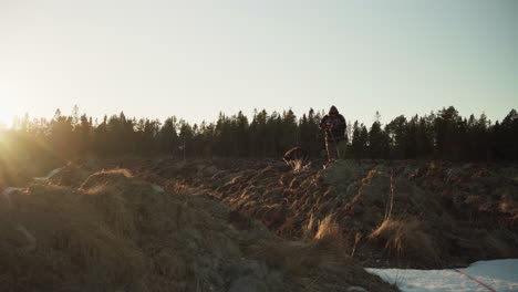 person with shovel digging soil at sunset in rural land