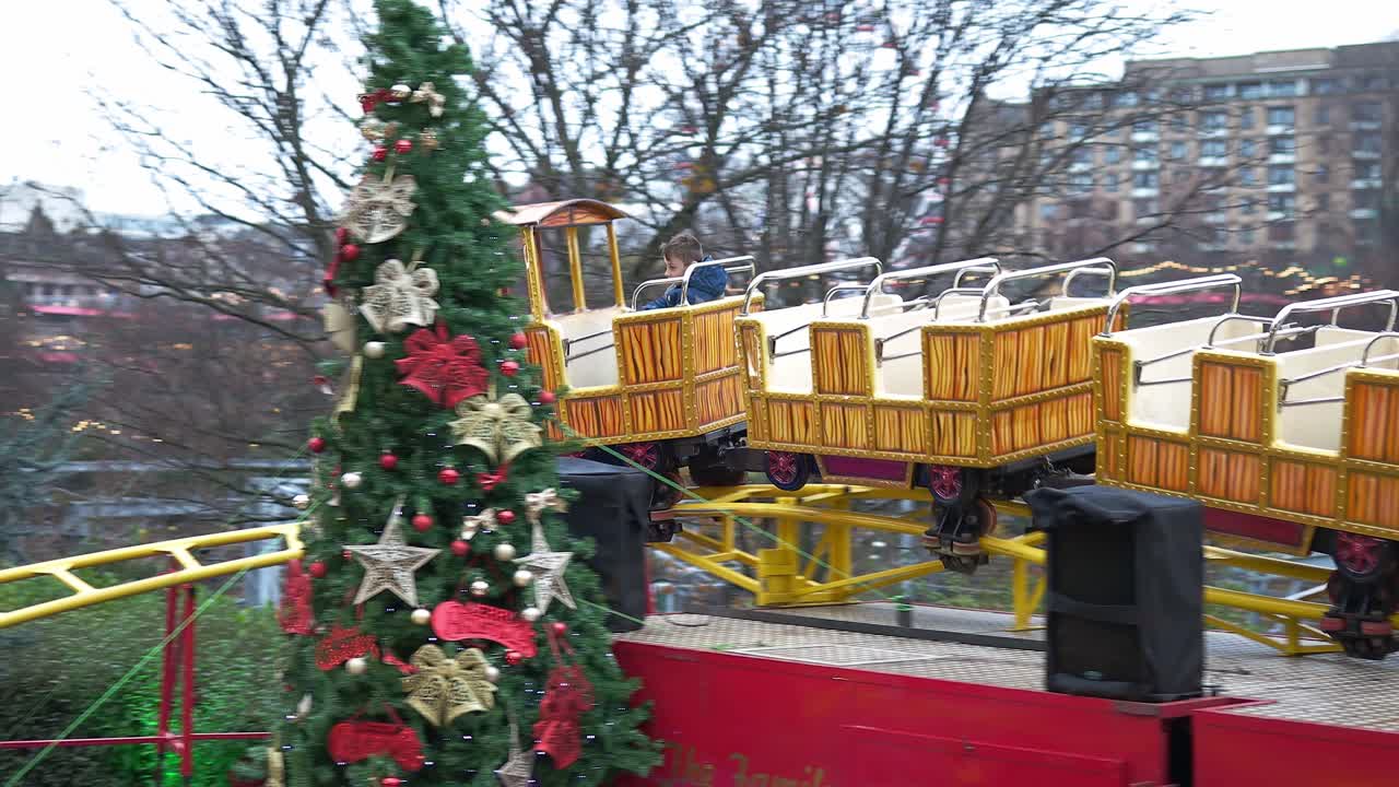 에딘버러 크리스마스 시장에서 박람회장 명소를 타고 즐거운 시간을 보내는 어린 소년