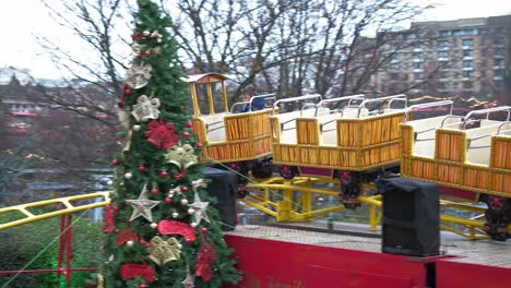 young boy having fun riding a fairground attraction at edinburgh christmas market