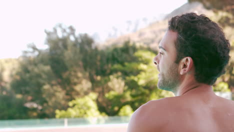hombre guapo relajándose en la piscina.