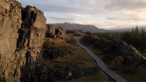 Isolierte-Und-Nicht-Erkennbare-Menschen,-Die-Auf-Einem-Gehweg-Laufen,-Der-Fehler-Oder-Risse-Des-Thingvellir-nationalparks-überquert