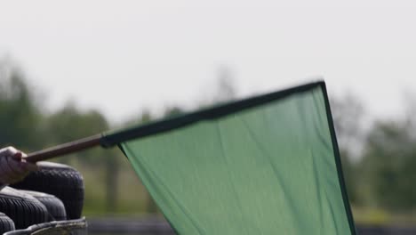 Green-flag-at-a-racetrack-waving-in-slowmo